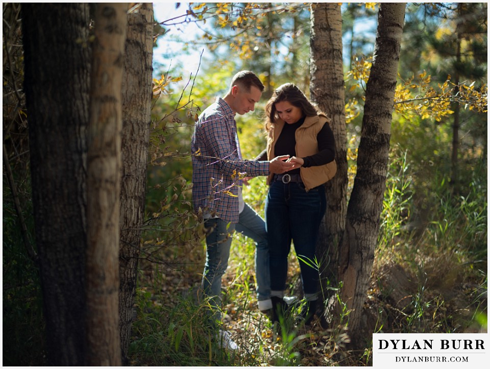 downtown estes park engagement photos holding hands in the early fall light