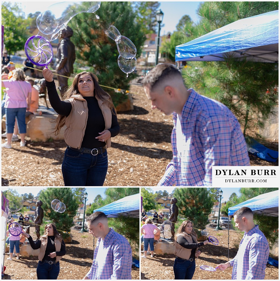 downtown estes park engagement photos playing with bubbles at a street festival