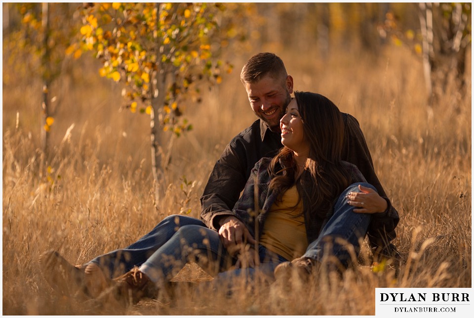 engagement photos golden colorado photographer couple laughing together in tall grass