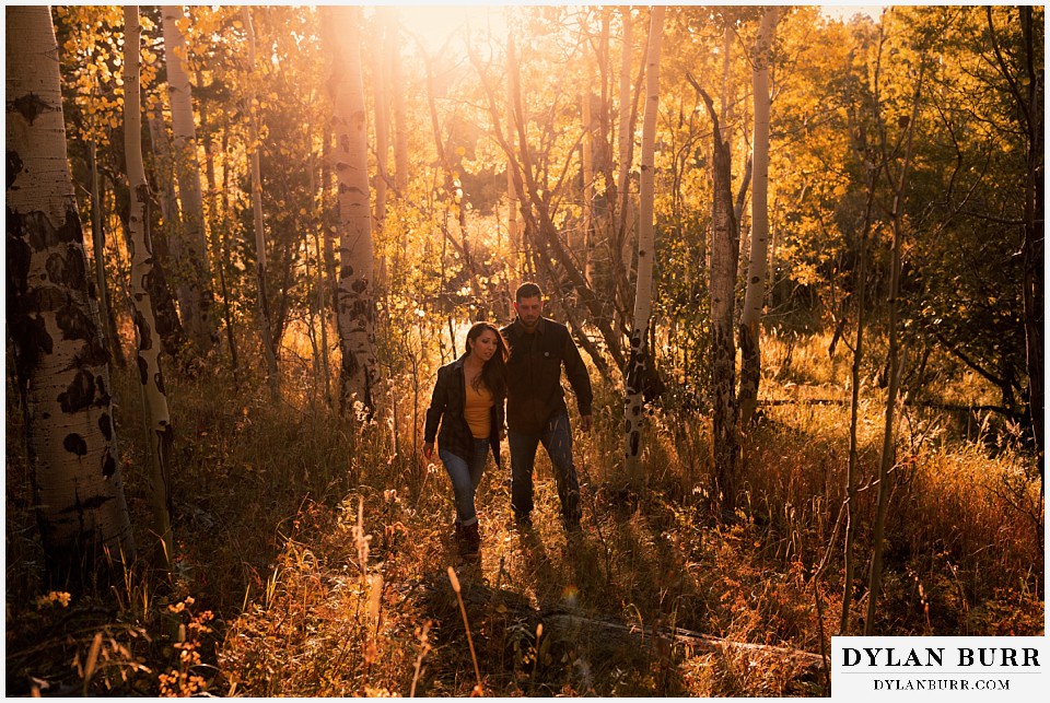 engagement photos golden colorado photographer couple walking out of aspen forest