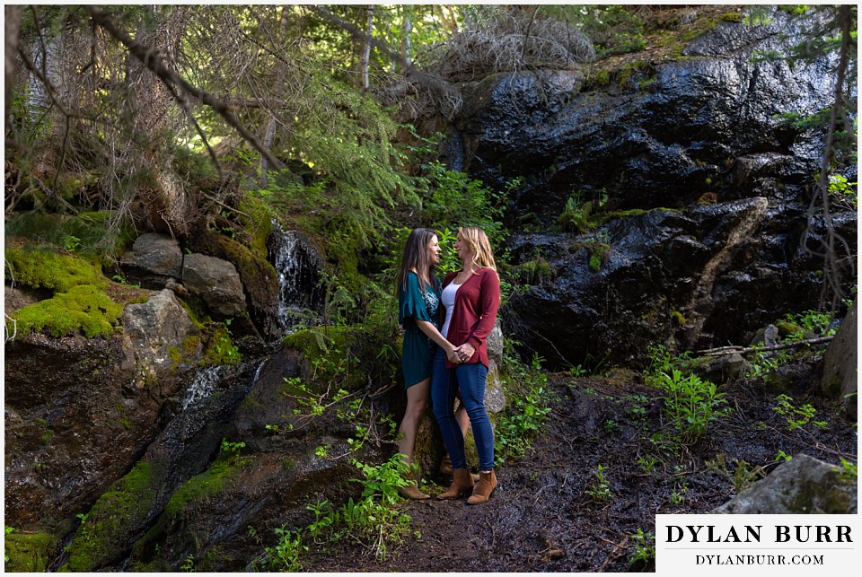 estes park engagement photos couple together near large wet rocks