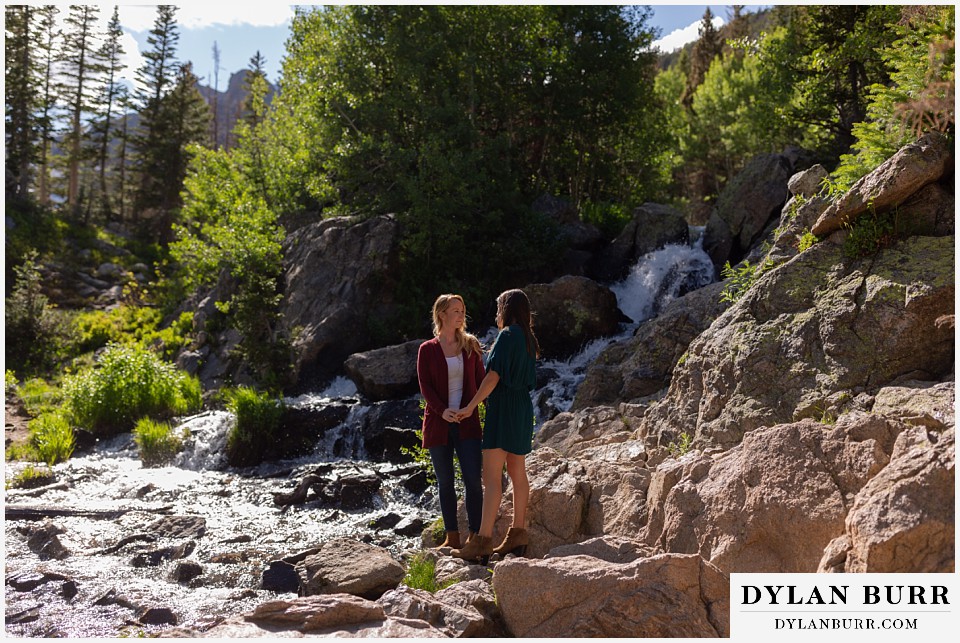 estes park engagement photos couple taking a moment near a mountain waterfall