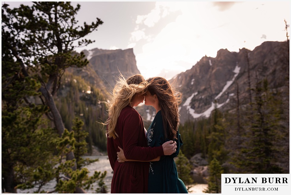 estes park engagement photos standing together in sunlight on top of large rocks