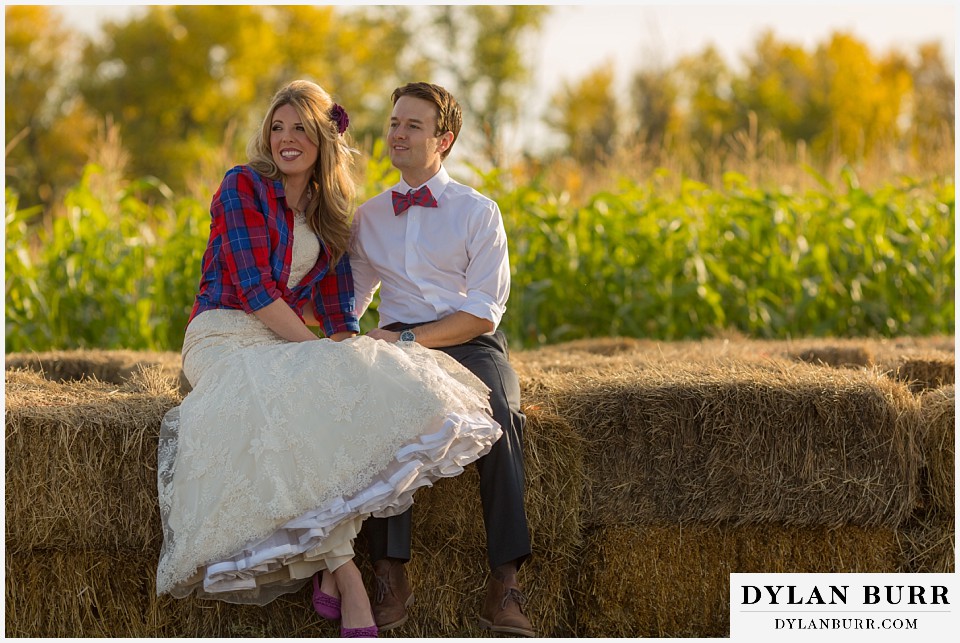 fall anniversary photos bride and groom sitting on hay bails