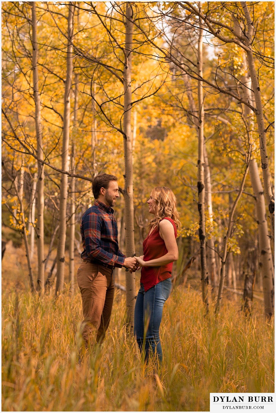 fall engagement photos in colorado couple holding hands looking at each other
