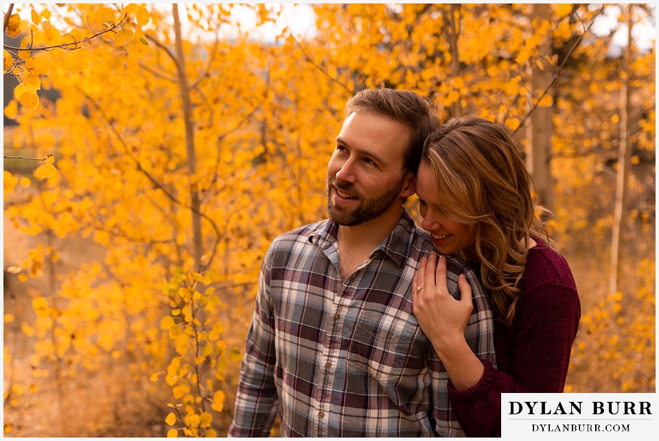 fall engagement photos in colorado couple snuggling in close