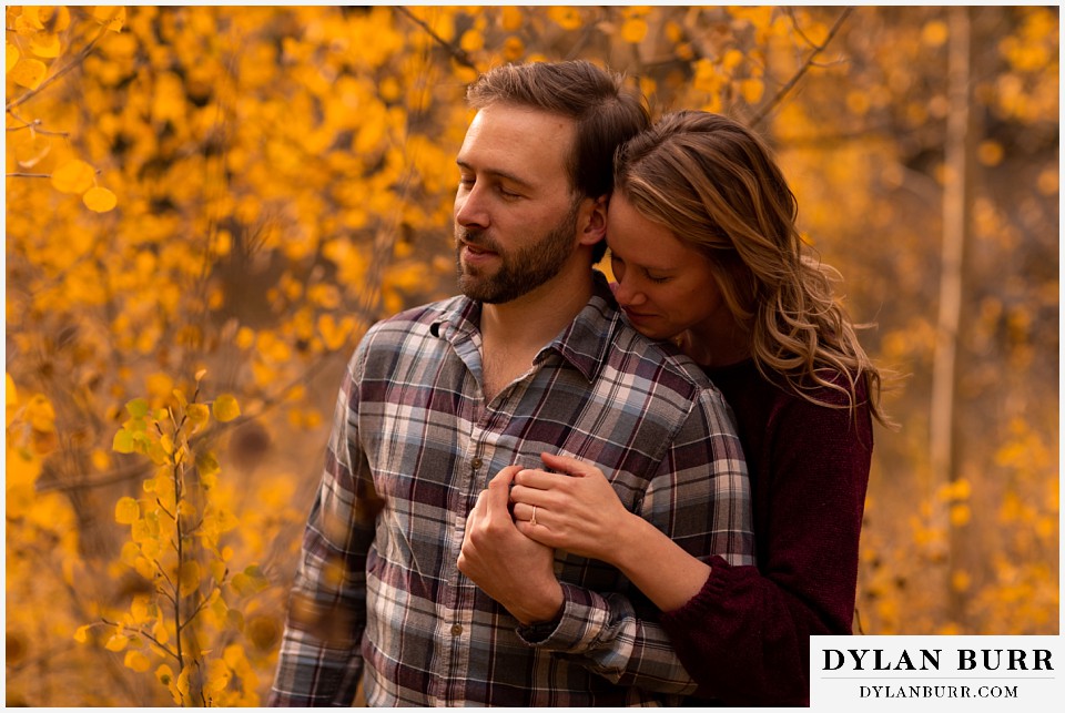 fall engagement photos in colorado couple taking a quite minute to listen to trees