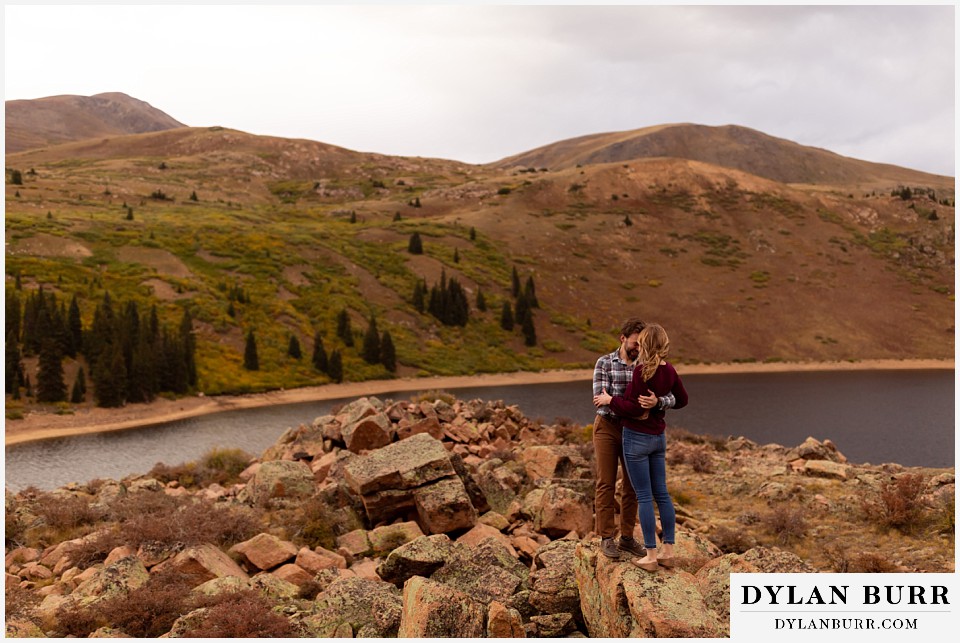 fall engagement photos in colorado couple on ridge together over mountain lake