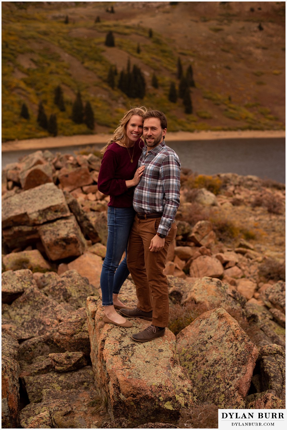 fall engagement photos in colorado couple looking back at photographer
