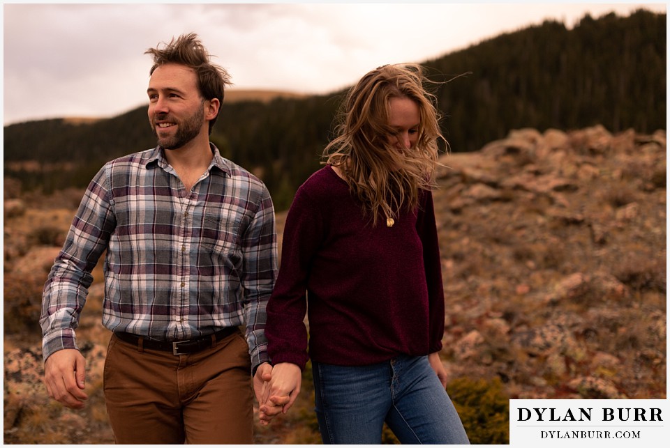 fall engagement photos in colorado couple together blowing in the wind
