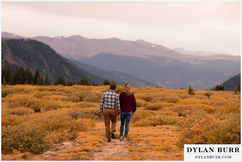 fall engagement photos in colorado walking together out in the mountain valley