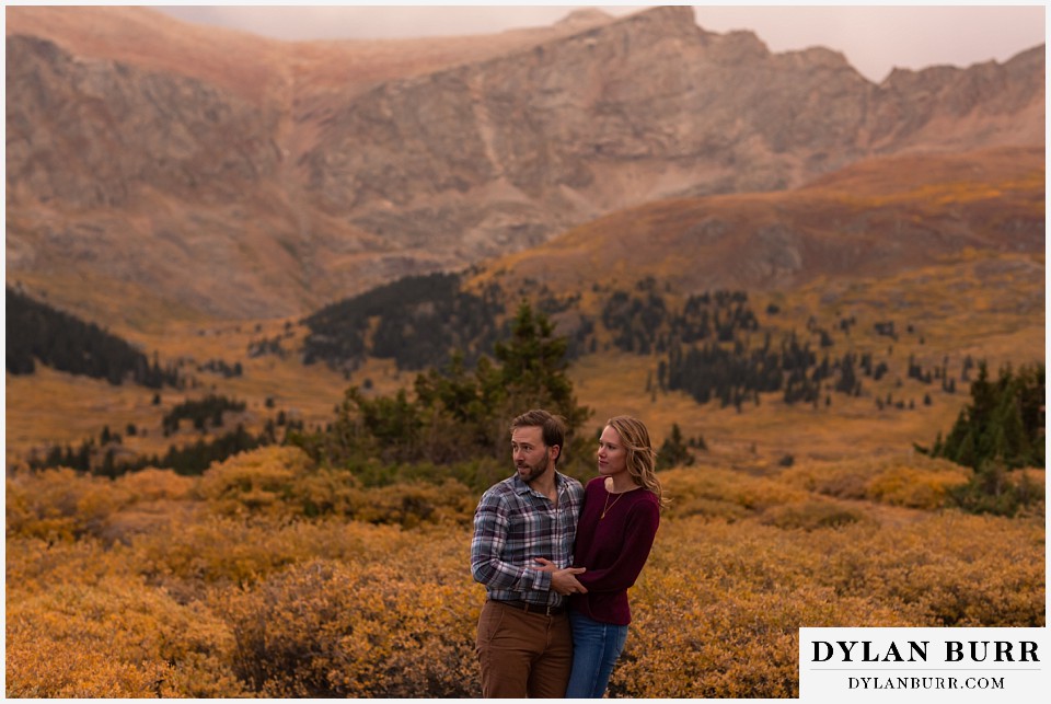 fall engagement photos in colorado couple looking down into the valley below