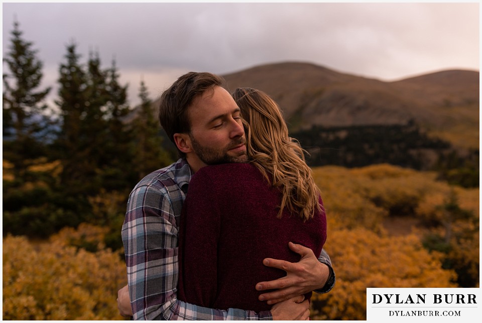 fall engagement photos in colorado he hugs her with so much love