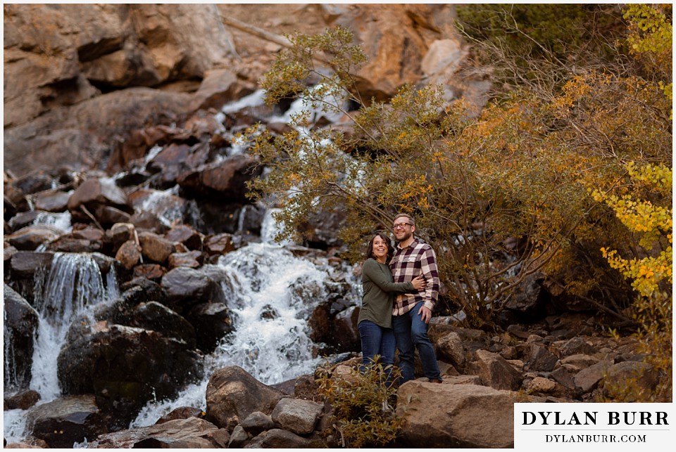 georgetown colorado engagement session couple standing near large waterfall