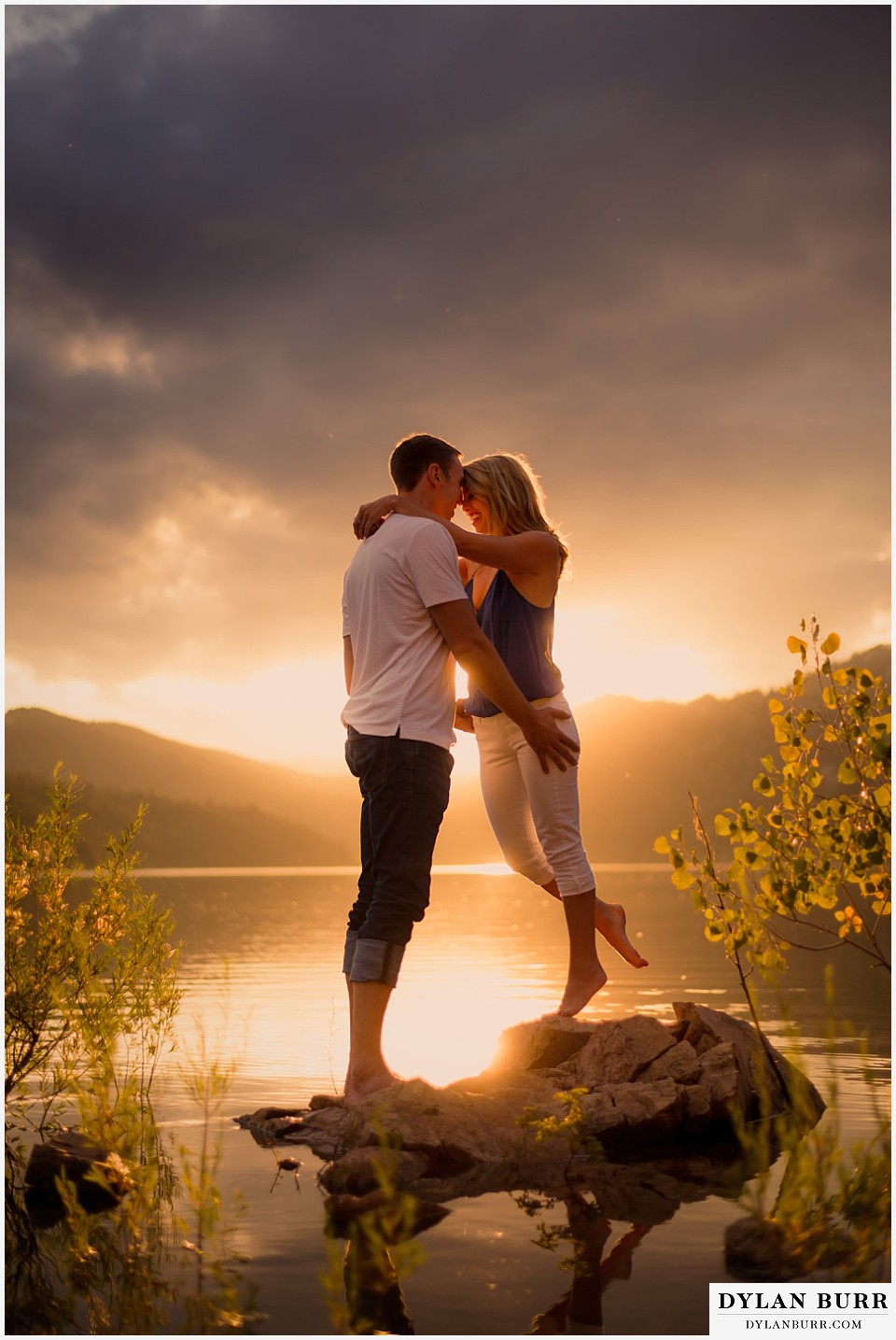 how to prepare for my engagement session couple standing on rock in incredible sunset