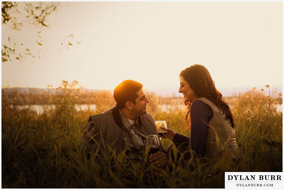 how to prepare for my engagement session couple drinking wine in field
