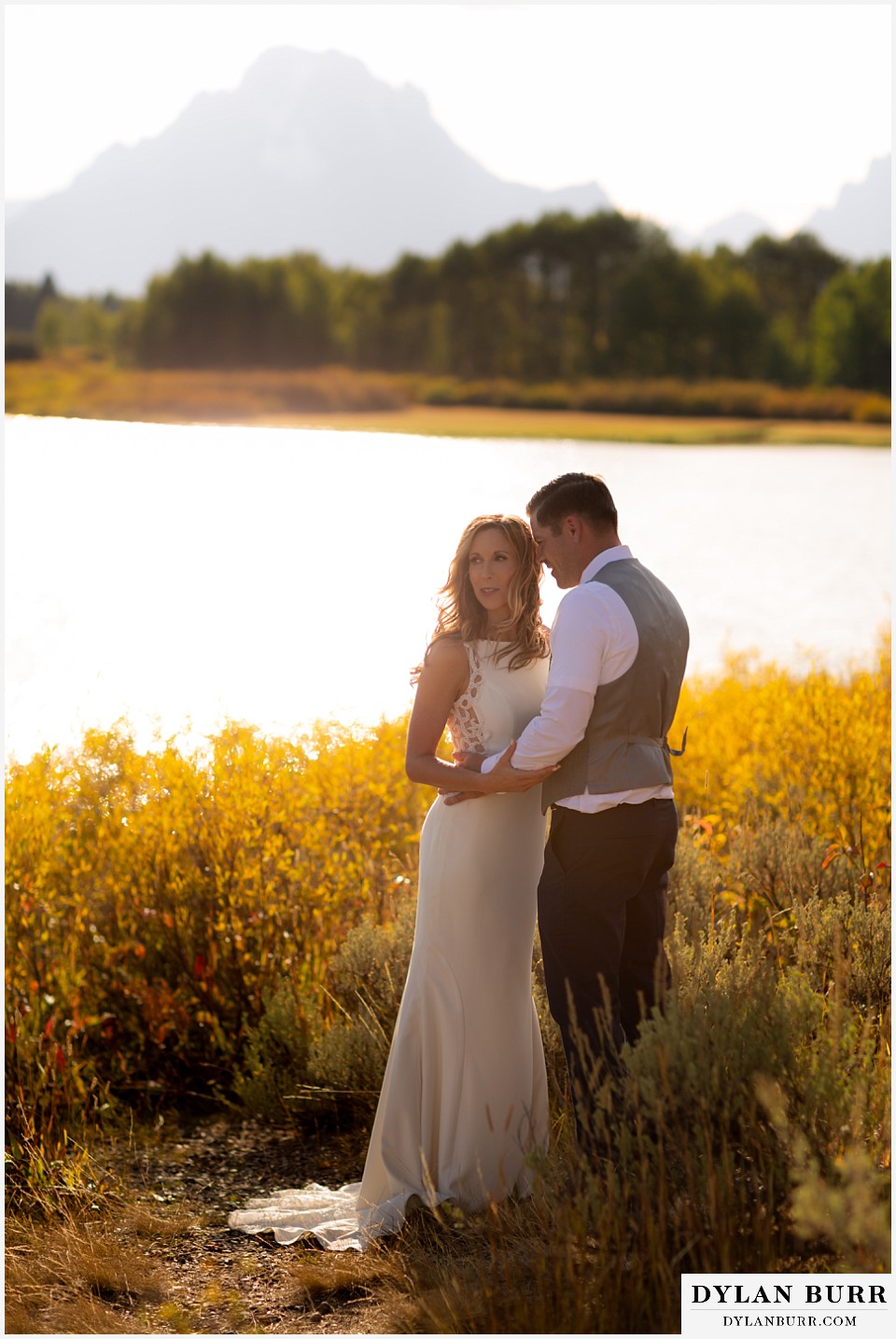 jackson lake lodge wedding grand tetons wyoming bride and groom in the fall by the snake river and mt moran