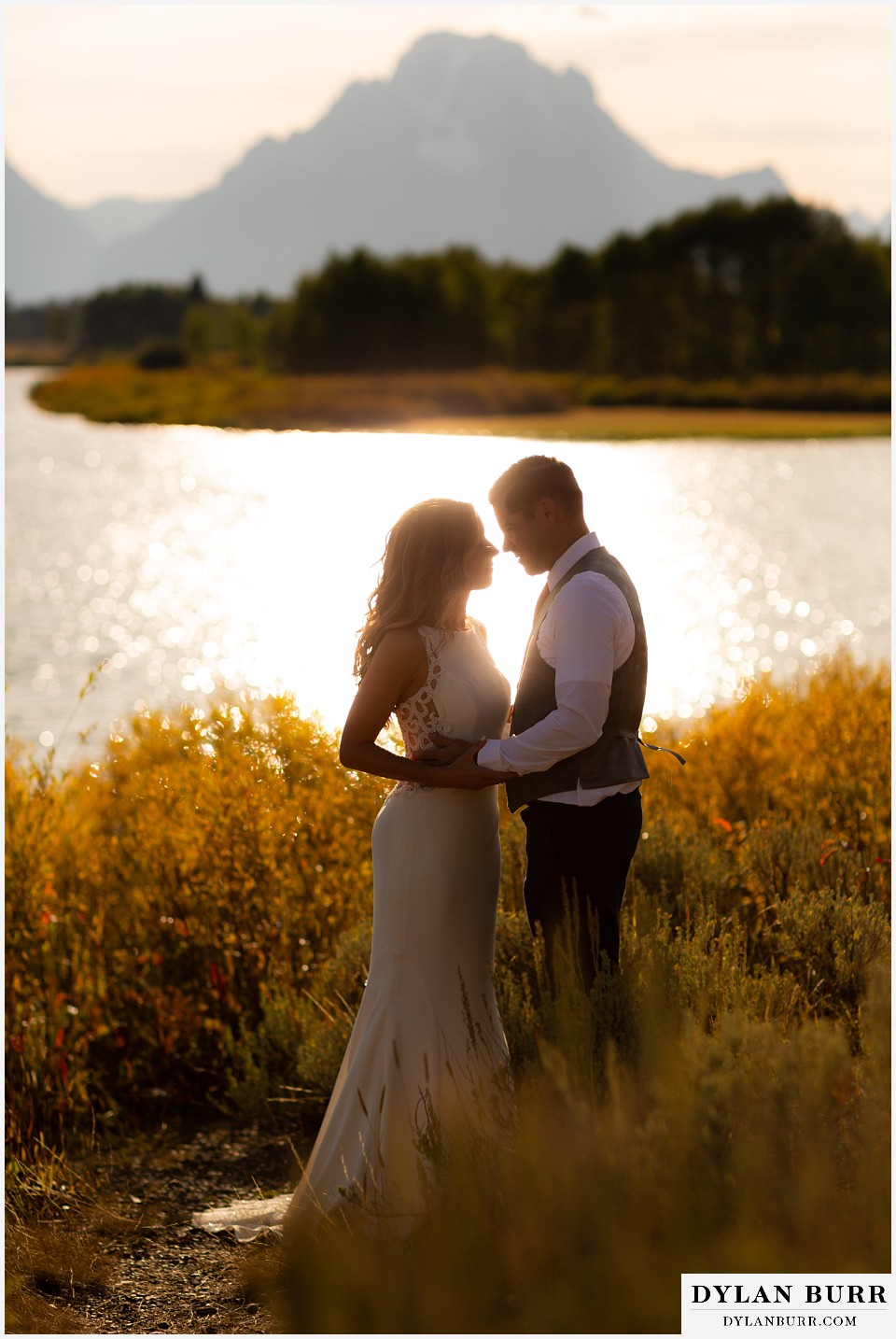 jackson lake lodge wedding grand tetons wyoming bride and groom standing in sunlight with mt moran in background