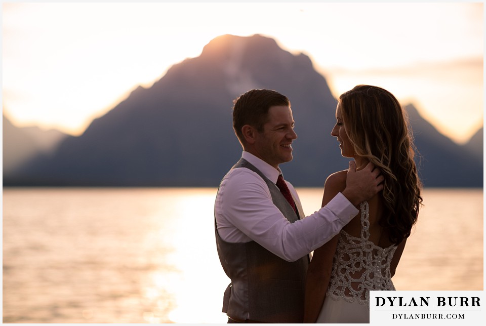 jackson lake lodge wedding grand tetons wyoming loving groom reaching out for his wife at sunset