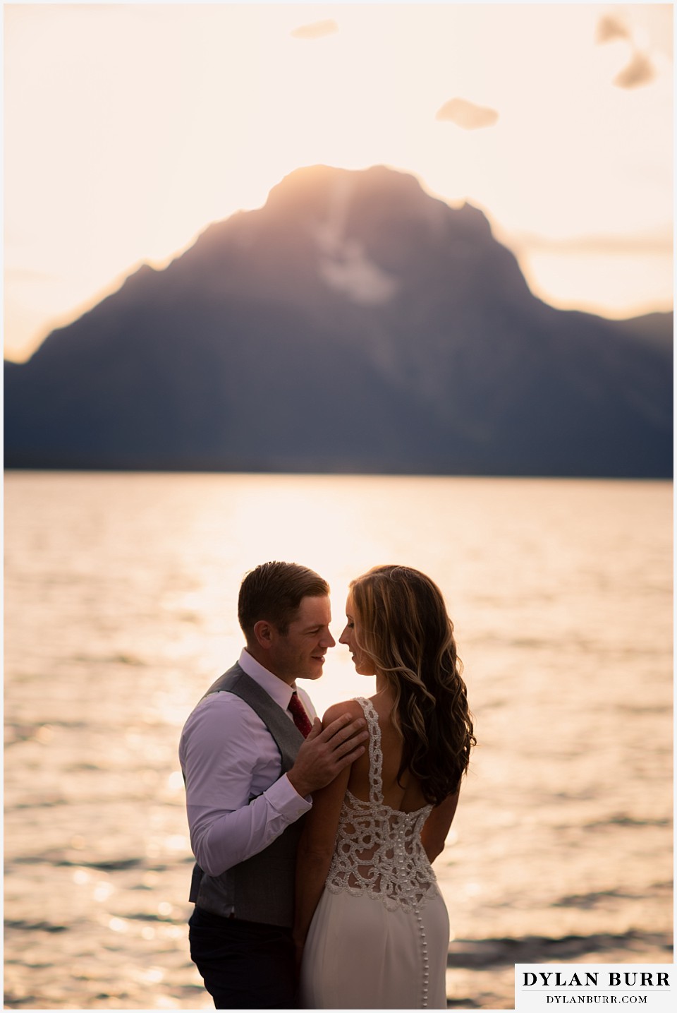 jackson lake lodge wedding grand tetons wyoming groom looking sweetly at his wife at sunset with mt mornan in background