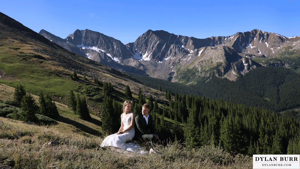 sunrise elopement wedding cinemagraph bride and groom sitting together in alpine meadow