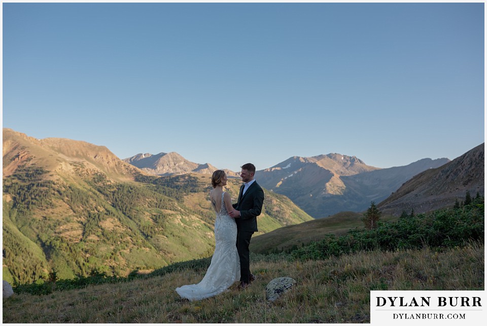 sunrise elopement wedding first look with bride on top of a mountain in colorado