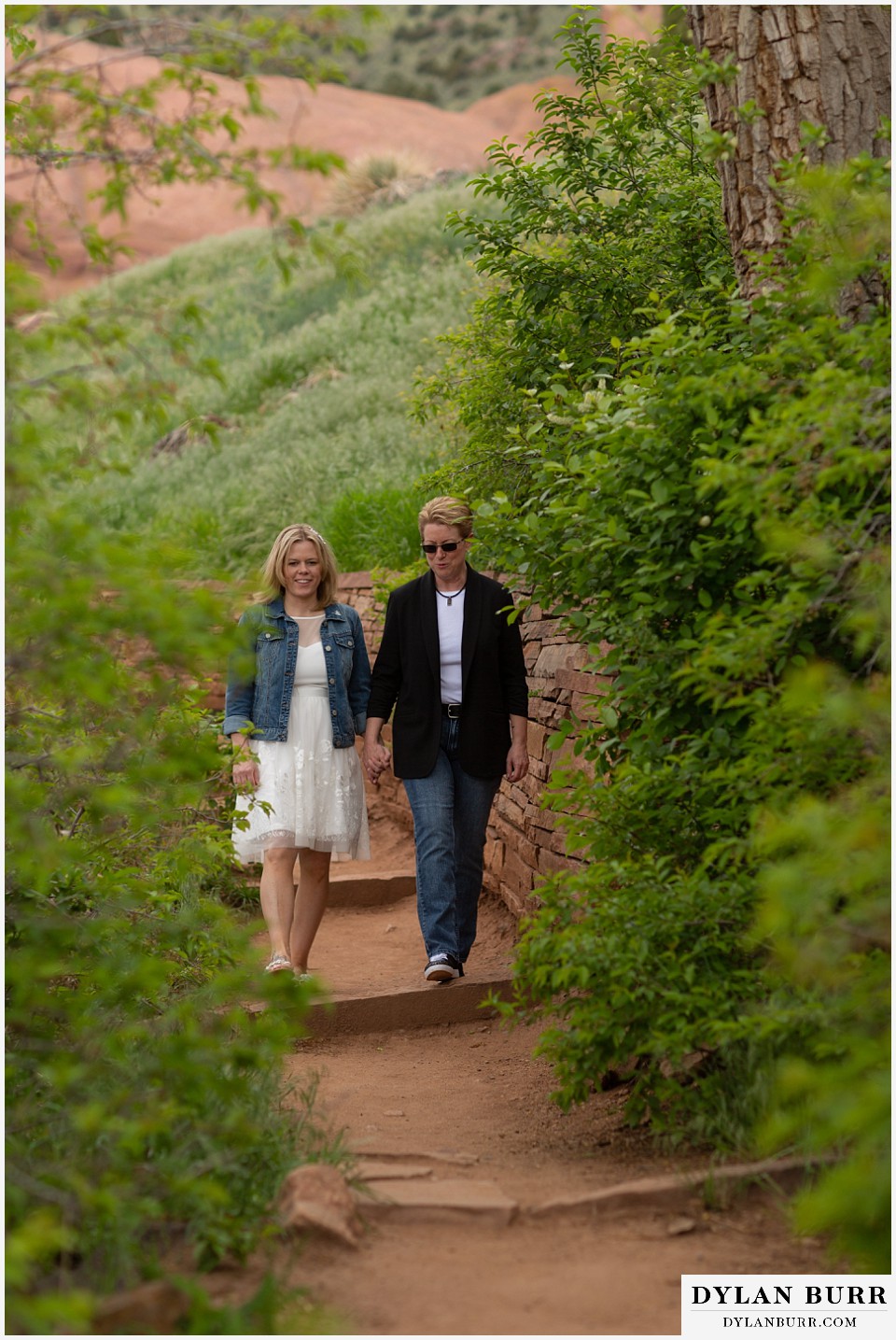 red rocks wedding morrison colorado couple walking together on an interesting green growth path