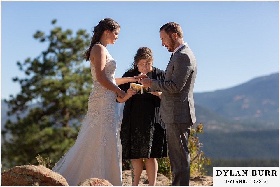 rocky mountain national park elopement wedding groom placing ring on brides finger