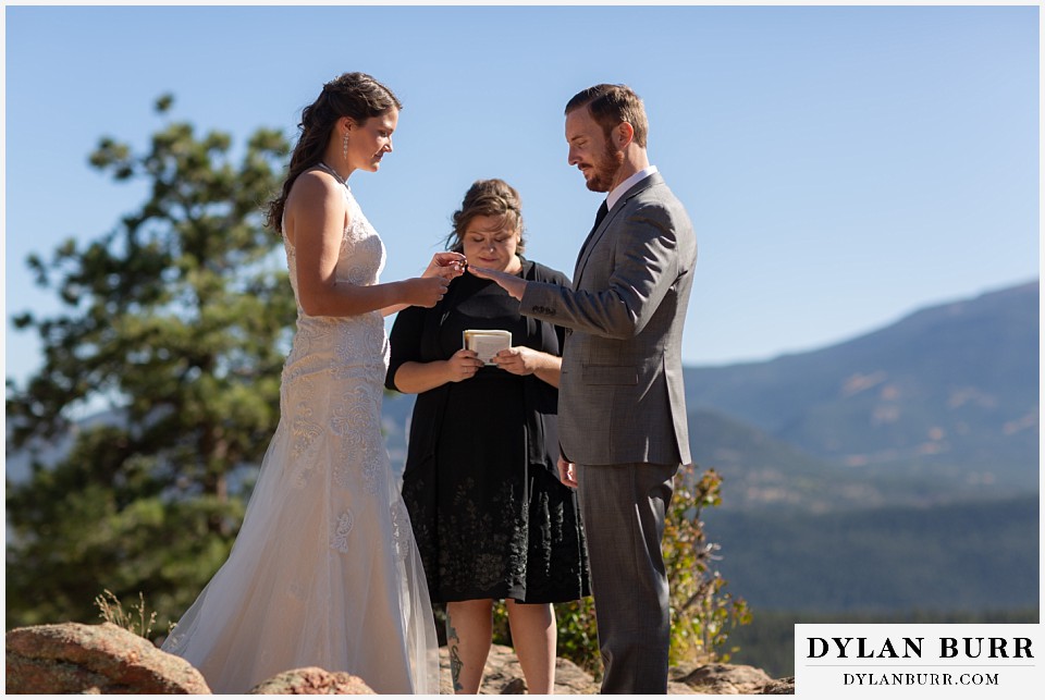 rocky mountain national park elopement wedding bride placing ring on grooms finger