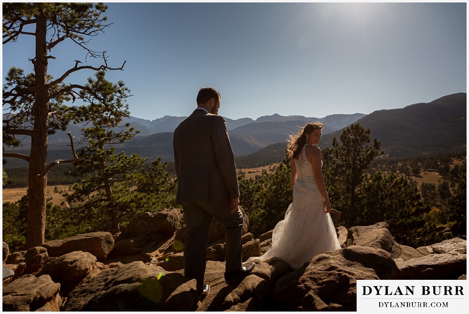 rocky mountain national park elopement wedding bride and groom walking in sunlight on mountain top