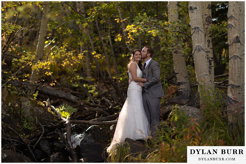 rocky mountain national park elopement wedding bride and groom near river in aspen forest