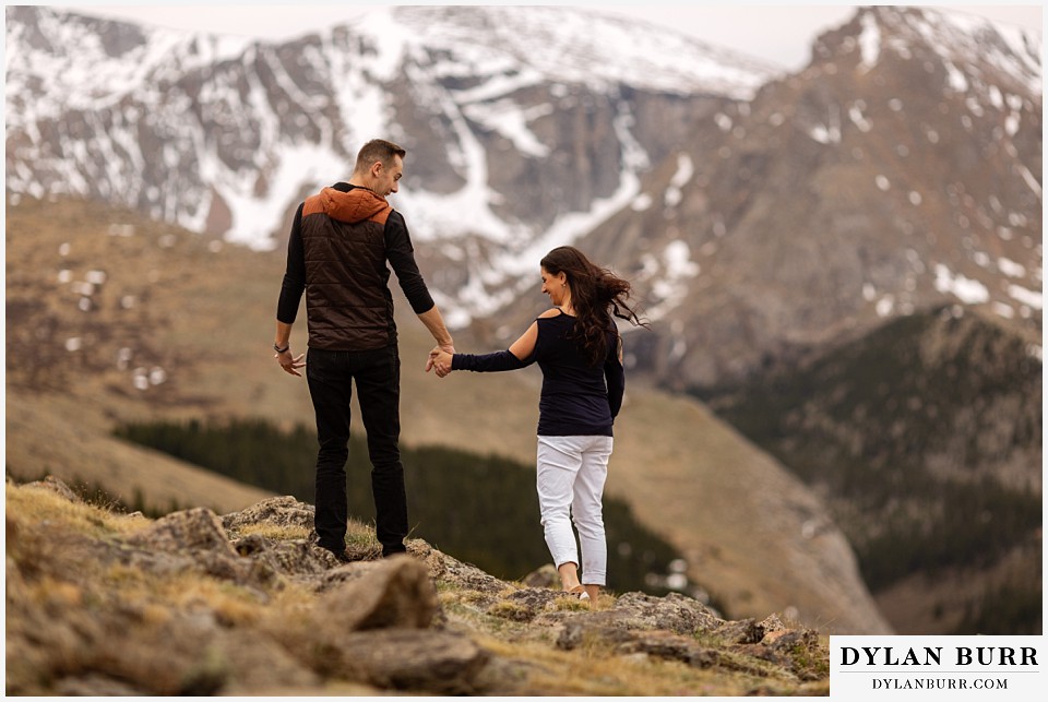 rocky mountain engagement session in colorado hiking with snowy mountains