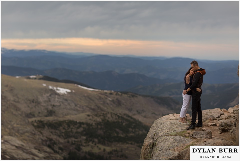 rocky mountain engagement session in colorado hugs on a mountain ledge
