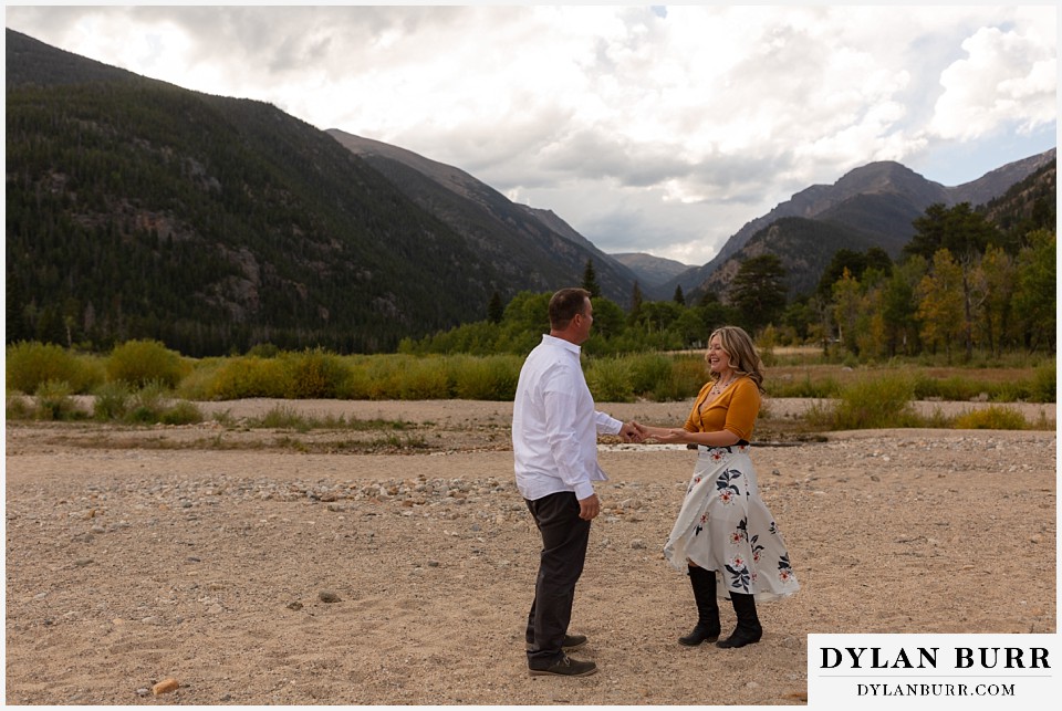 rocky mountain national park elopement wedding bride and groom dancing together near river