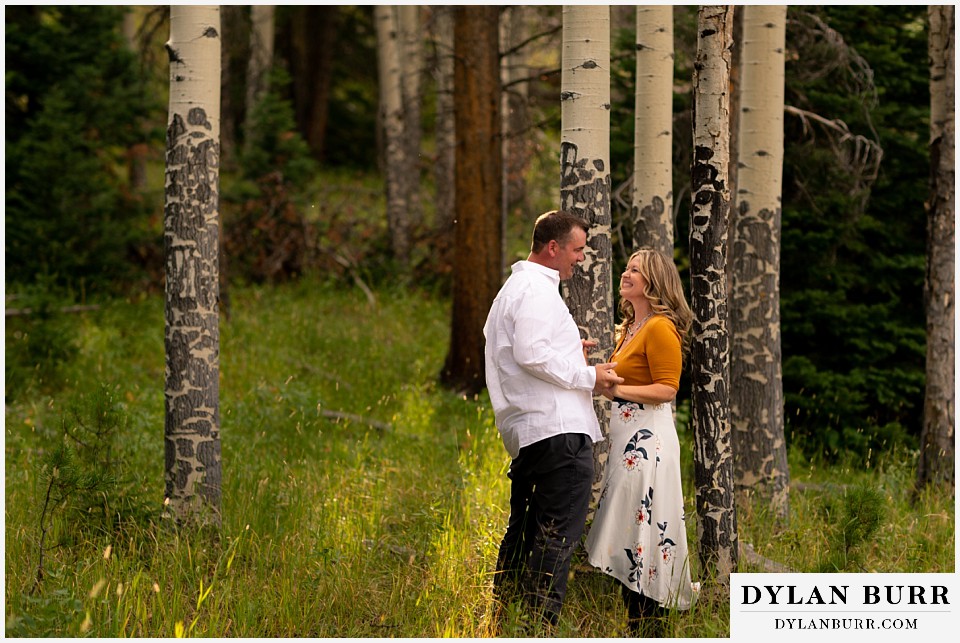 rocky mountain national park elopement wedding couple holding hands in sun and trees