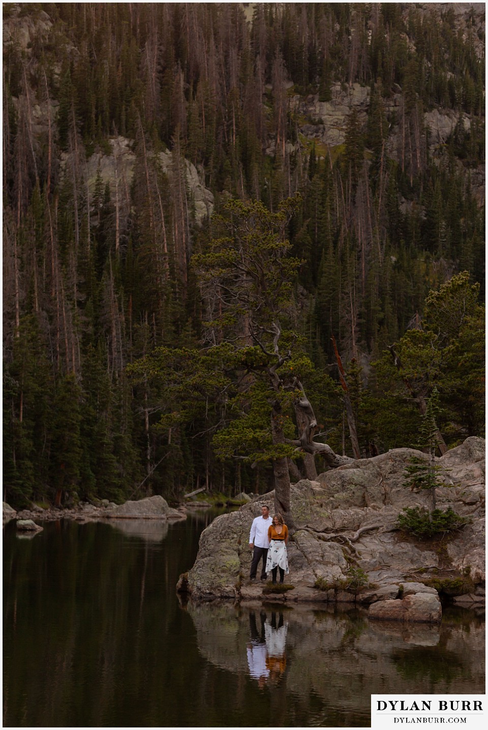 rocky mountain national park elopement wedding couple looking at their reflection in a mountain lake