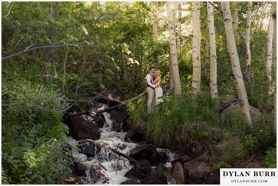 rocky mountain national park wedding elopement bride and groom near a rushing waterfall deep in forest