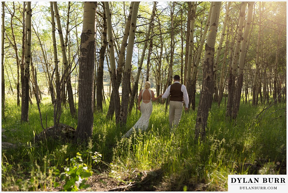 rocky mountain national park wedding elopement bride and groom walking in aspen grove
