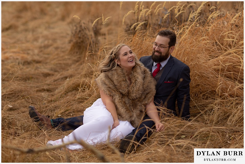 rocky mountain national park wedding elopement bride and groom sitting together in fall tall grass