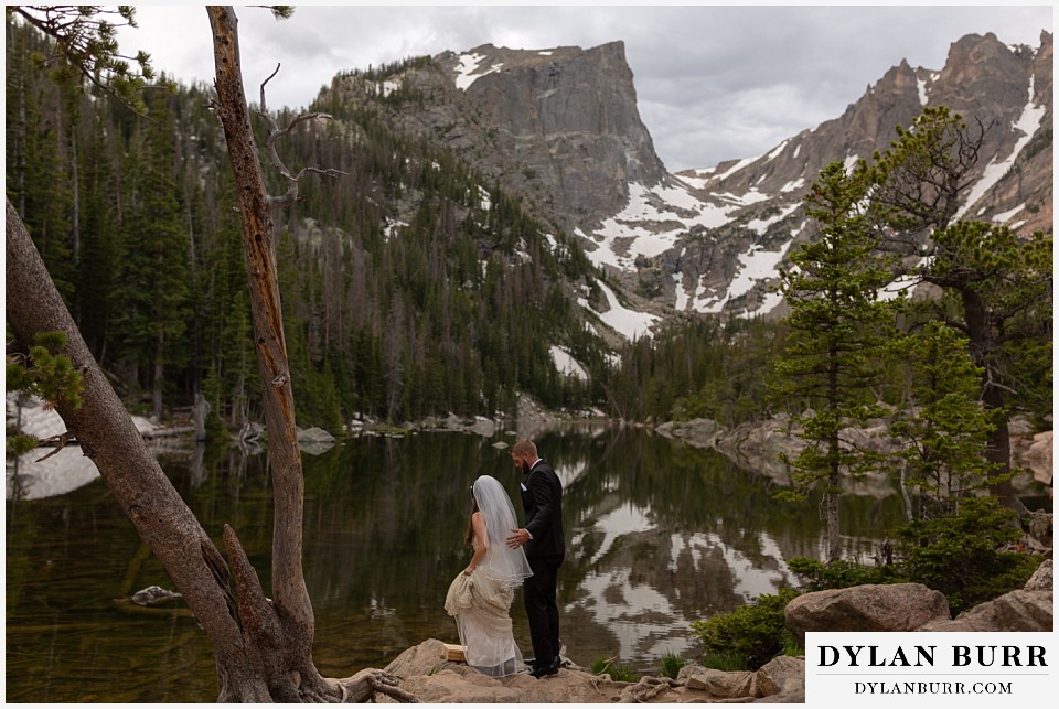 rocky mountain national park wedding elopement colorado wedding photographer dylan burr bride and groom walking up to high alpine mountain lake