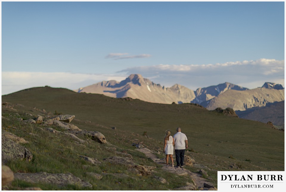spring engagement photo session walking in alpine mountain meadow with longs peak in the background