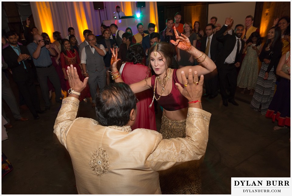 spruce mountain ranch wedding indian wedding bride and grooms father dancing together