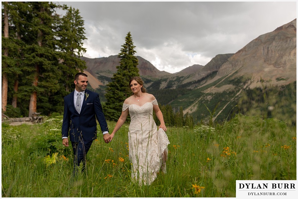 telluride colorado elopement wedding adventure bride and groom holding hands while high in mountains