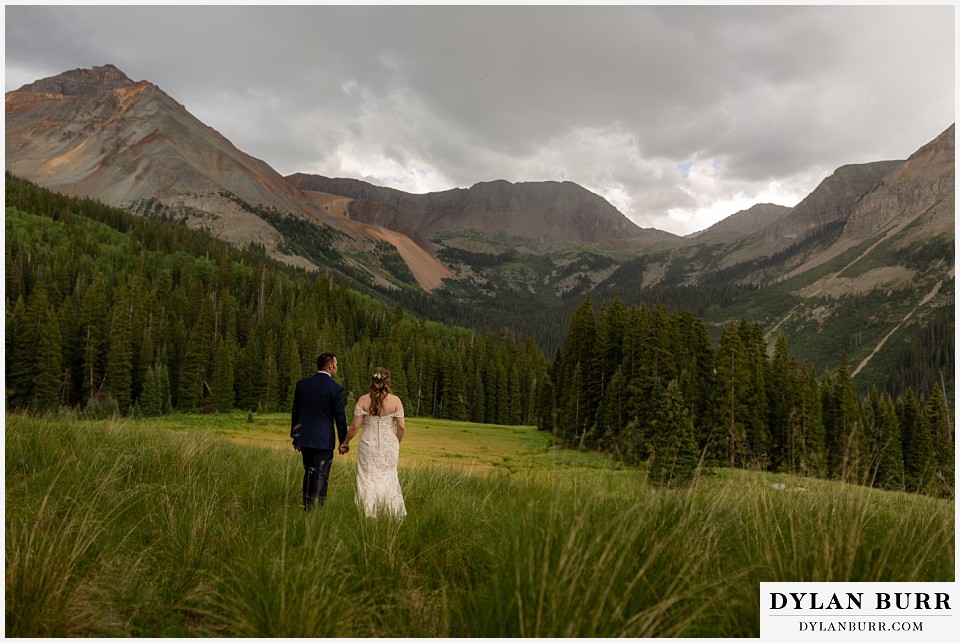 telluride colorado elopement wedding adventure bride and groom looking at giant mountain range that surrounds them