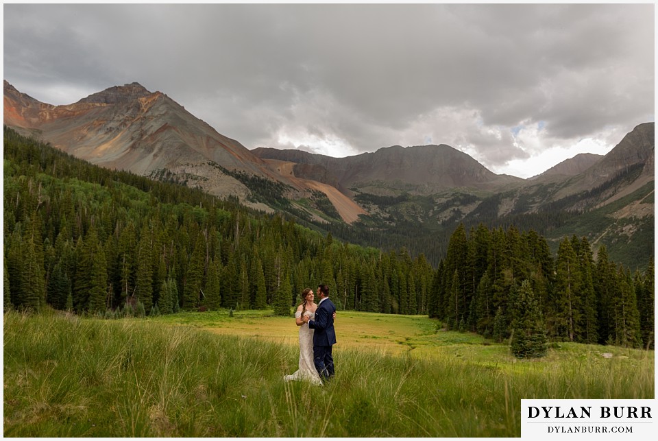 telluride colorado elopement wedding adventure bride and groom dancing in the rain in mountains