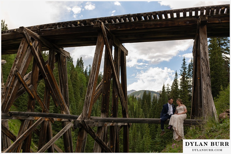 telluride colorado elopement wedding adventure bride and groom resting on a train trellis bridge