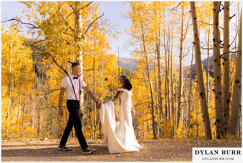 winter park mountain lodge wedding colorado bride and groom walking together on road alongside aspen trees