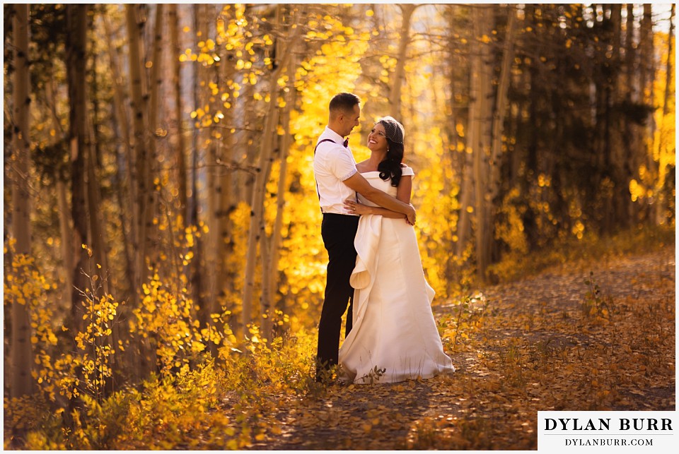 winter park mountain lodge wedding colorado bride and groom by fall leaves in forest